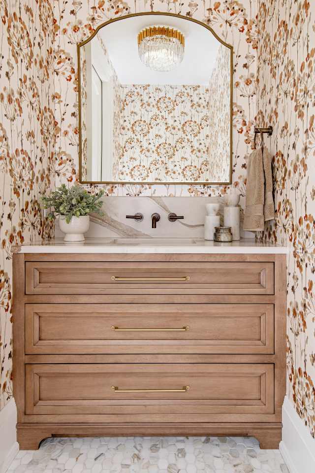 brass vintage light fixture in designer bathroom with wallpaper